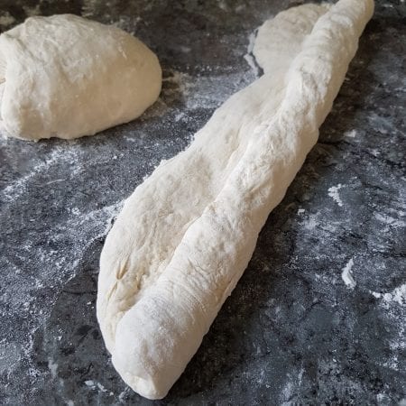 Façonnage d’une baguette maison : pâte roulée sur un plan fariné avant la levée et la cuisson