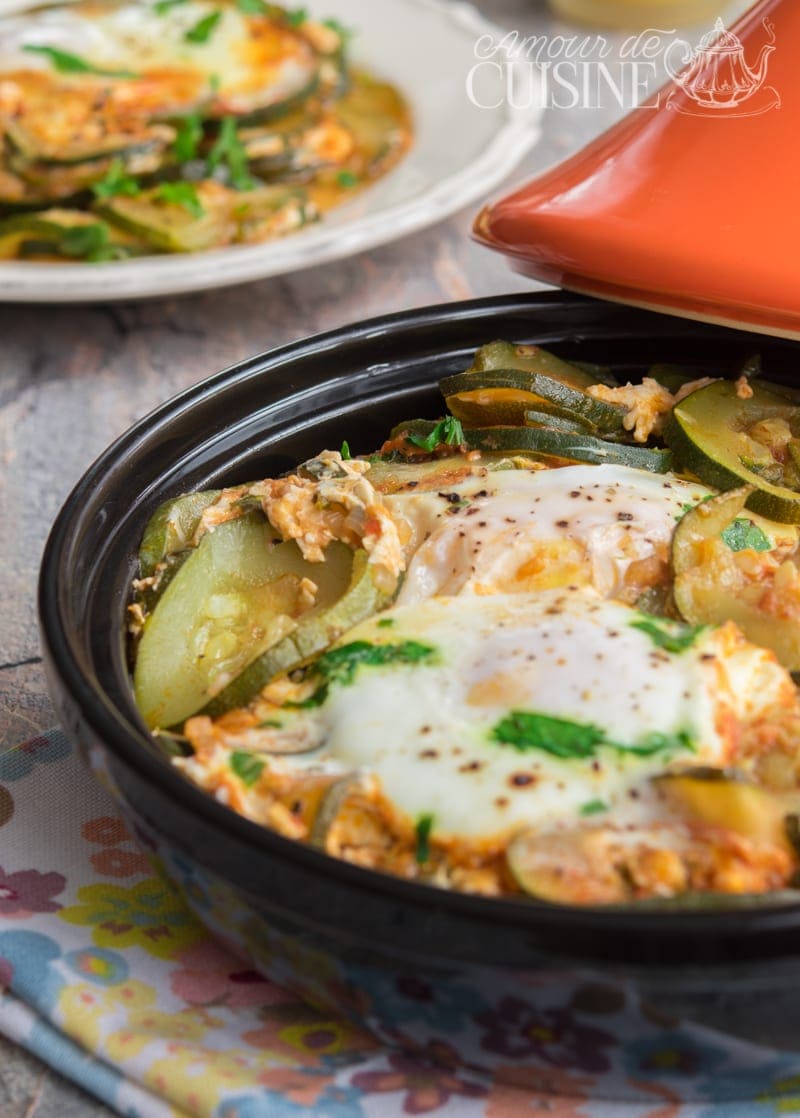 Tajine de courgettes aux oeufs, trebia algérienne fondante servie dans un plat noir avec coriandre fraîche