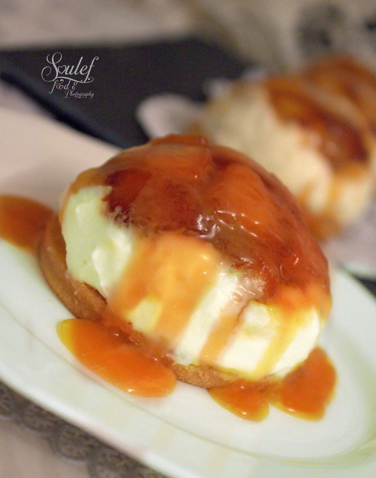 Dessert crémeux à la ricotta et pommes caramélisées sur sablé croquant, nappé généreusement de caramel au beurre salé, présenté sur une assiette blanche, avec une texture fondante et gourmande