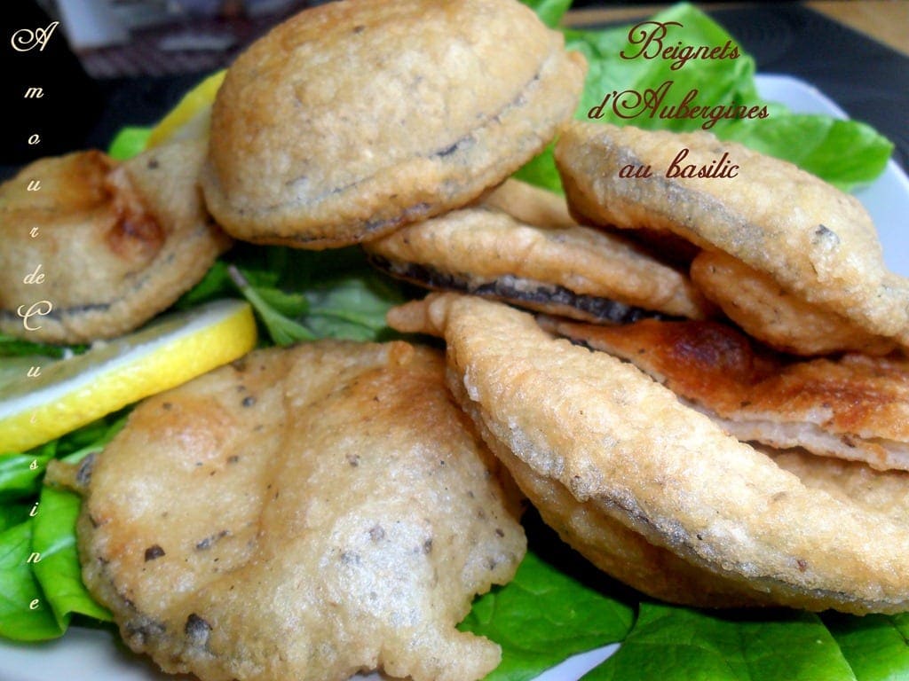 Beignets d’aubergines au basilic faits maison, croustillants et dorés, servis sur un lit de salade avec des tranches de citron