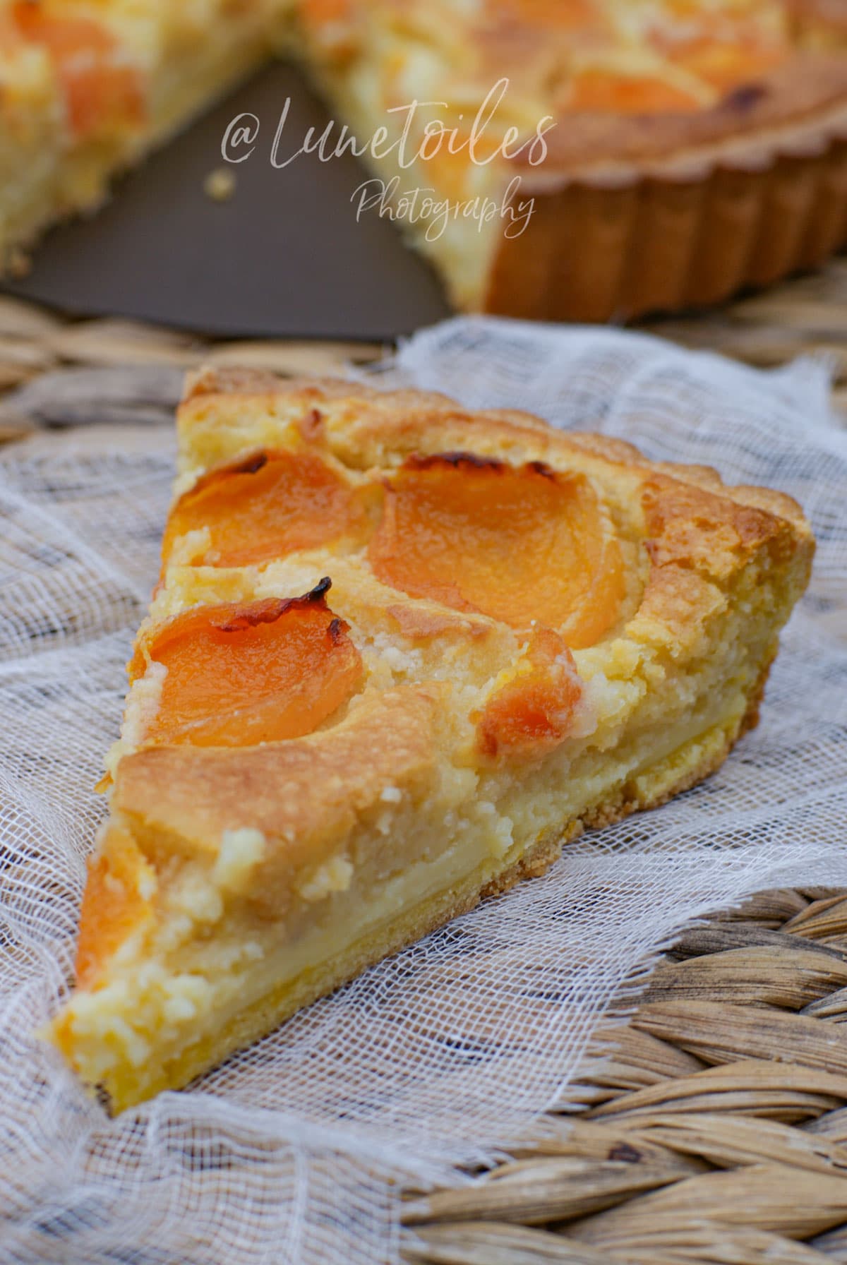 Part de tarte aux abricots et crème d’amande, garnie d’abricots dorés sur une pâte sucrée maison