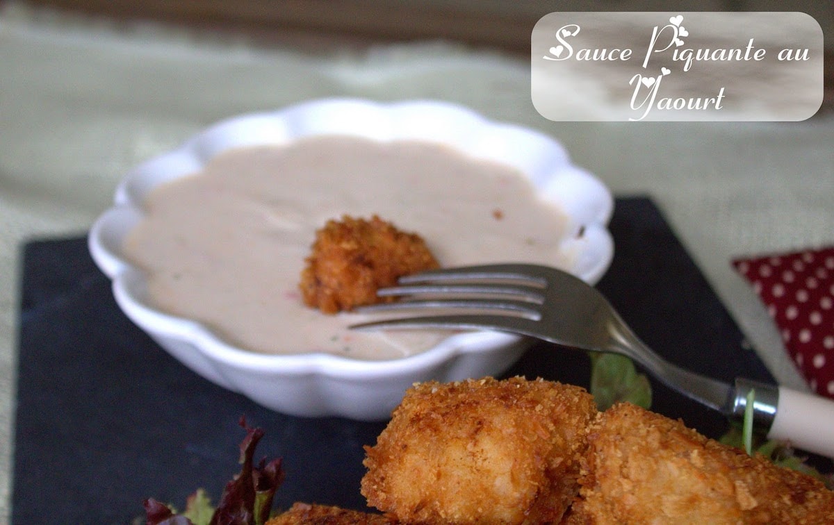Nuggets de poulet trempée dans une sauce piquante au yaourt maison, servie dans un bol blanc avec salade en accompagnement