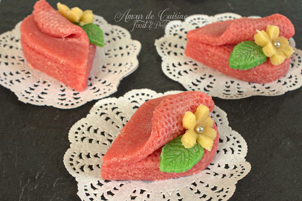 Harissa aux amandes ou taminet elouz, petits gâteaux algériens roses décorés de fleurs jaunes et feuilles vertes.