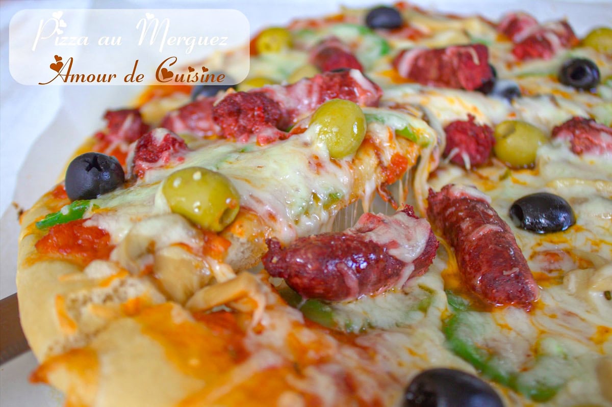 Pizza maison garnie de merguez, olives vertes et noires, fromage fondu et pâte moelleuse, présentée en part généreuse