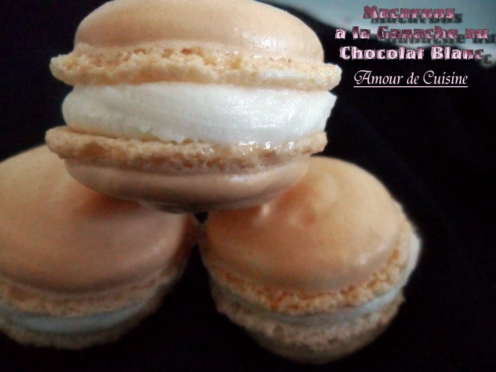 Macarons maison garnis d’une ganache chocolat blanc fondante, avec des coques beiges et une crème généreuse au centre.