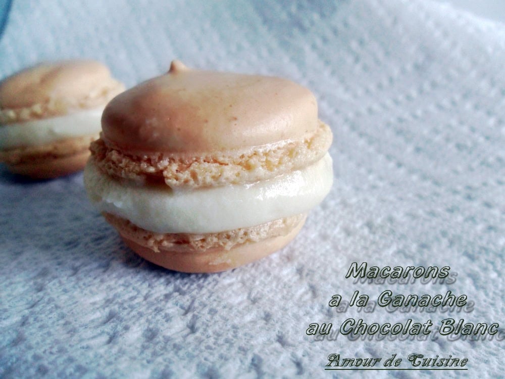 Macaron garni de ganache chocolat blanc, avec une coque beige et une crème fondante au centre.