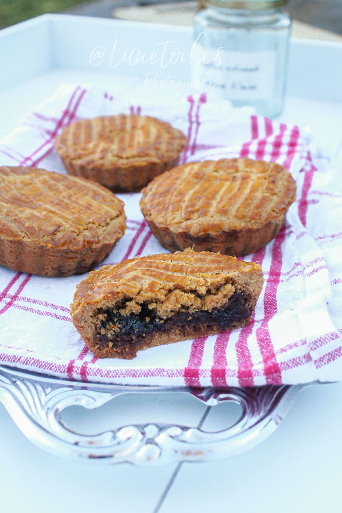 Gâteaux basques individuels à la confiture de cerises noires, avec une part coupée montrant la garniture fondante.