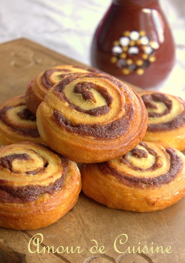 Roulés à la cannelle faits maison présentés sur une planche en bois – recette de viennoiserie moelleuse et dorée signée Amour de Cuisine
