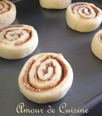 Roulés à la cannelle maison crus, disposés sur une plaque avant cuisson – pâte feuilletée levée garnie de sucre et cannelle, recette de viennoiserie en préparation signée Amour de Cuisine