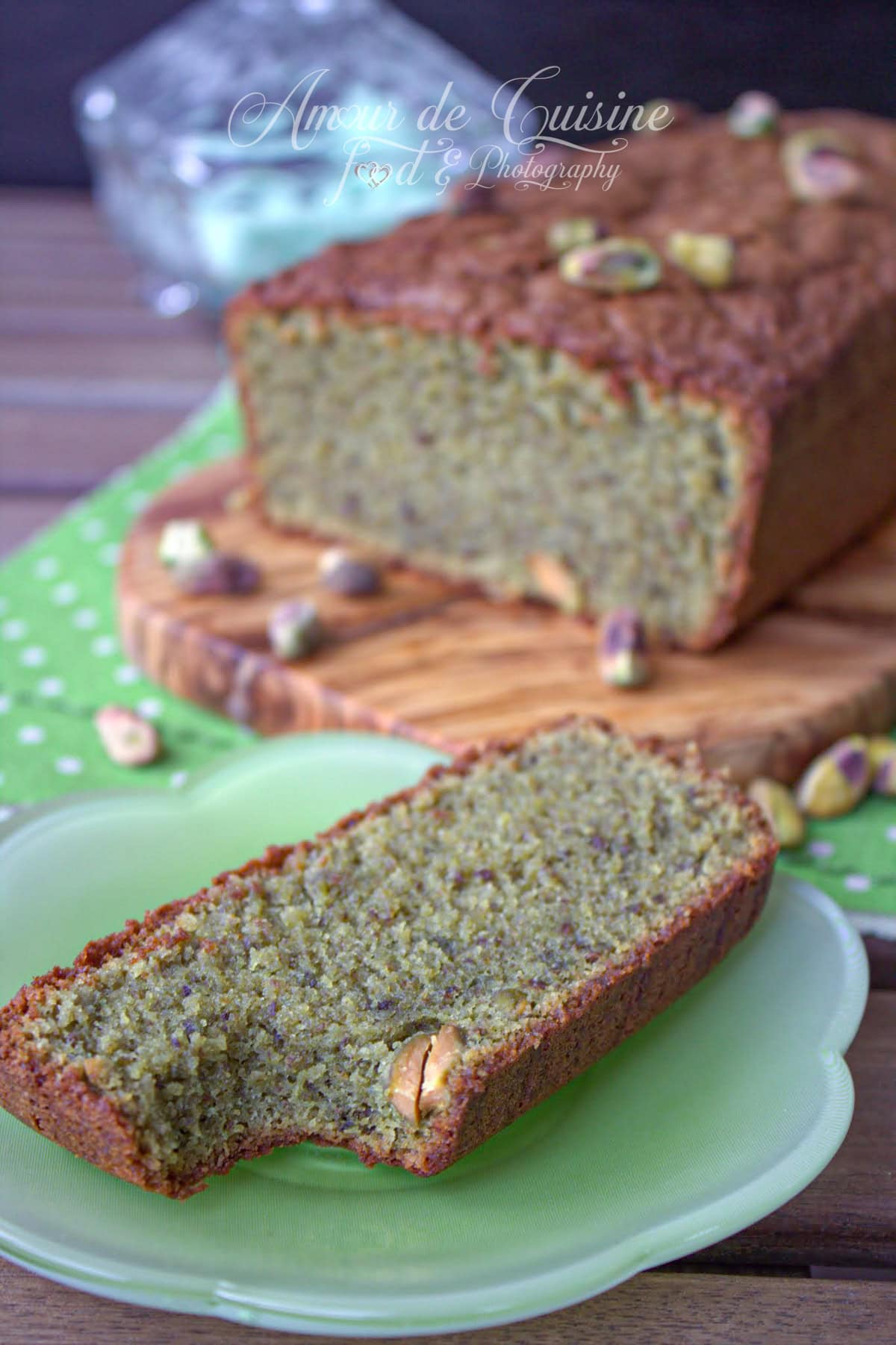 Tranche de cake à la pistache maison moelleux avec pâte de pistache, présenté sur une assiette verte, gâteau gourmand aux fruits secs, recette facile et savoureuse