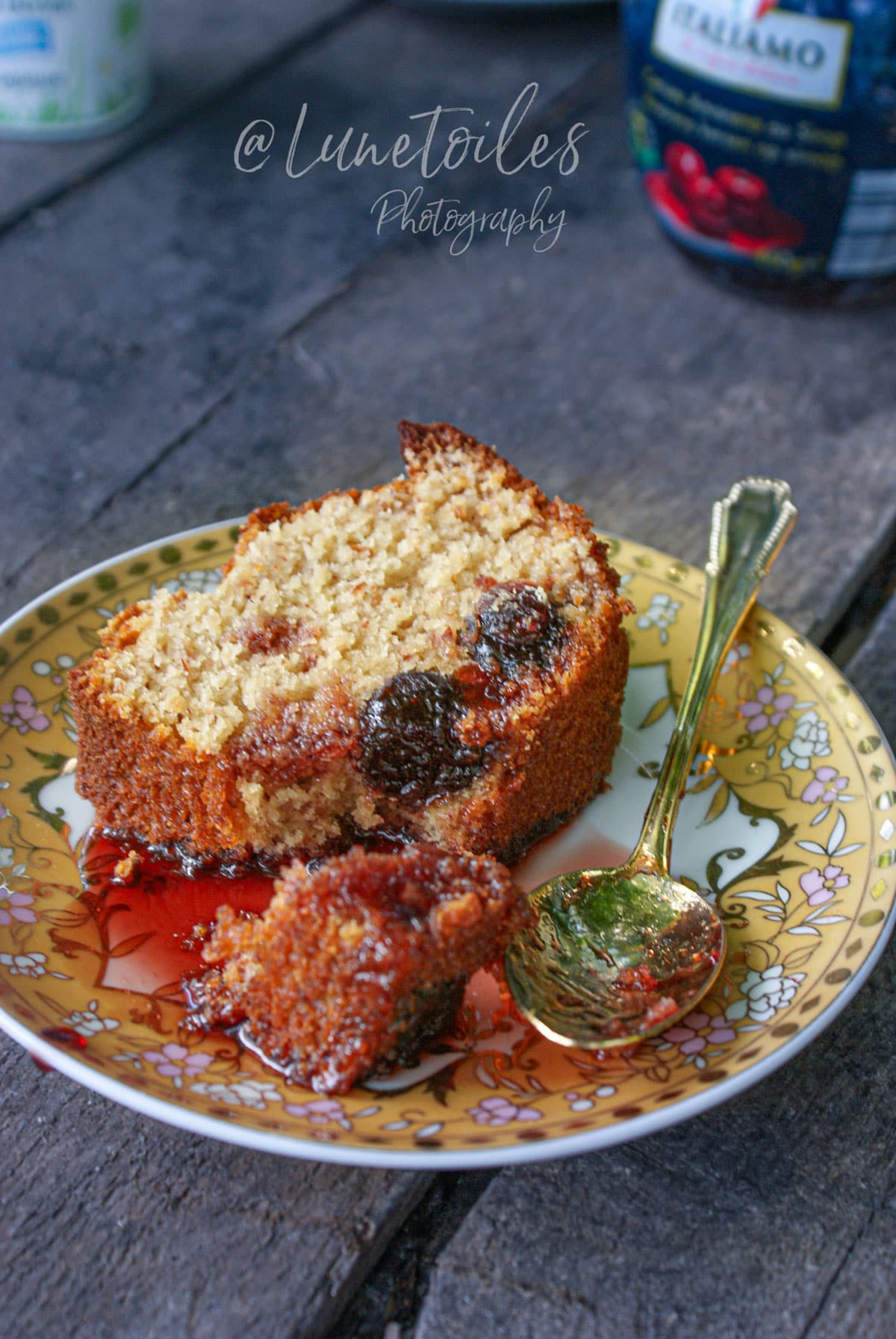 Part de gâteau aux cerises Amarena moelleux au yaourt et aux amandes, servie avec du sirop de cerises