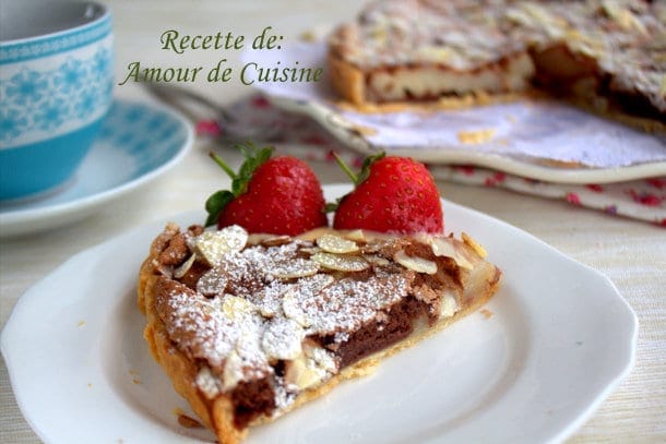 un morceau de la tarte aux poires et chocolat présenté avec des fraises.