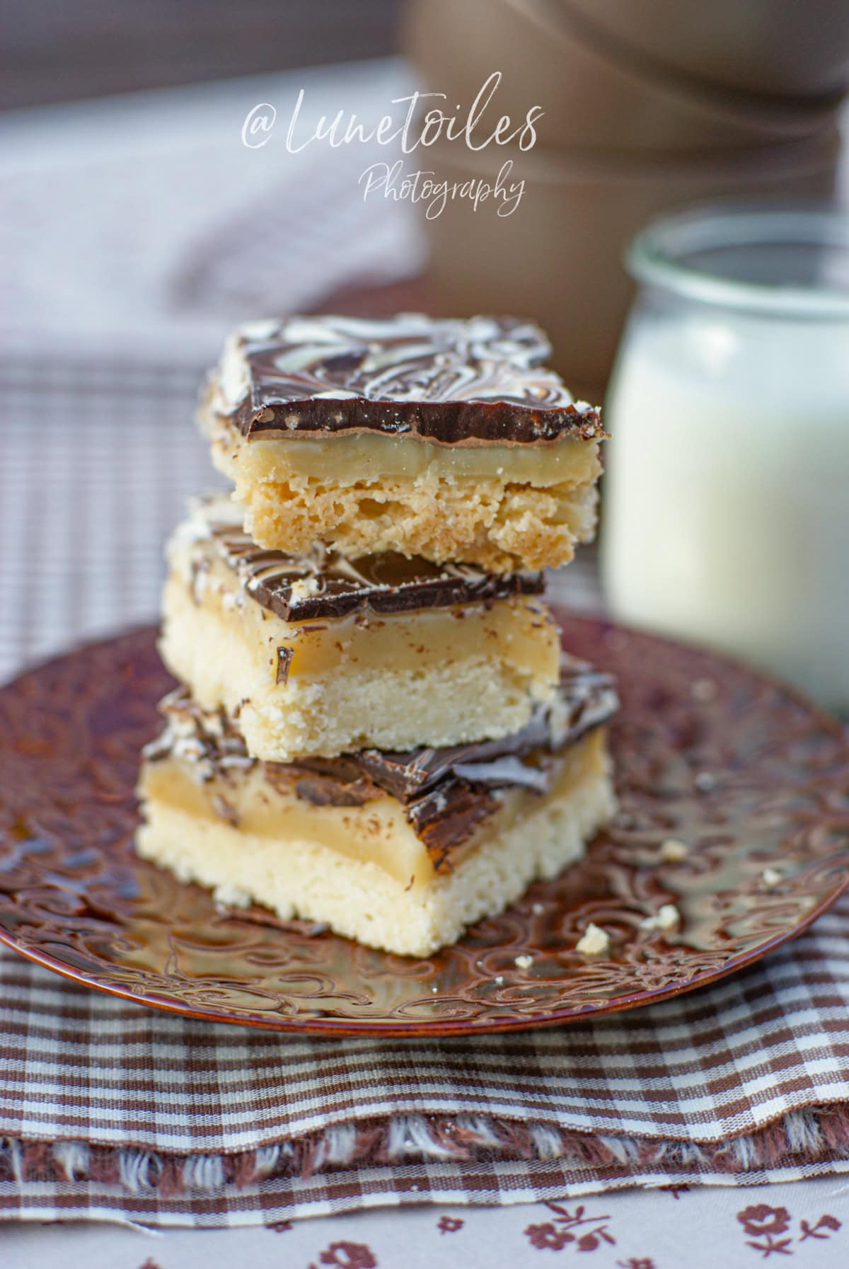 Shortbread millionnaire maison à trois couches : sablé, caramel fondant et chocolat marbré, servi sur une assiette vintage