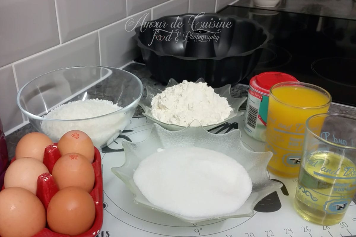 Ingrédients du gâteau à l’orange moelleux avec œufs, farine, sucre, noix de coco, jus d’orange et huile.
