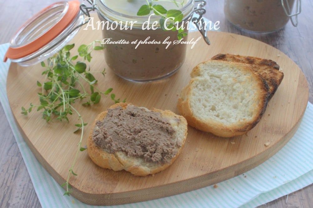 Tartine de pain grillé tartinée de terrine de foie de volaille, servie sur une planche en bois avec une tranche de toast, des brins de thym frais et des bocaux de terrine en arrière-plan.