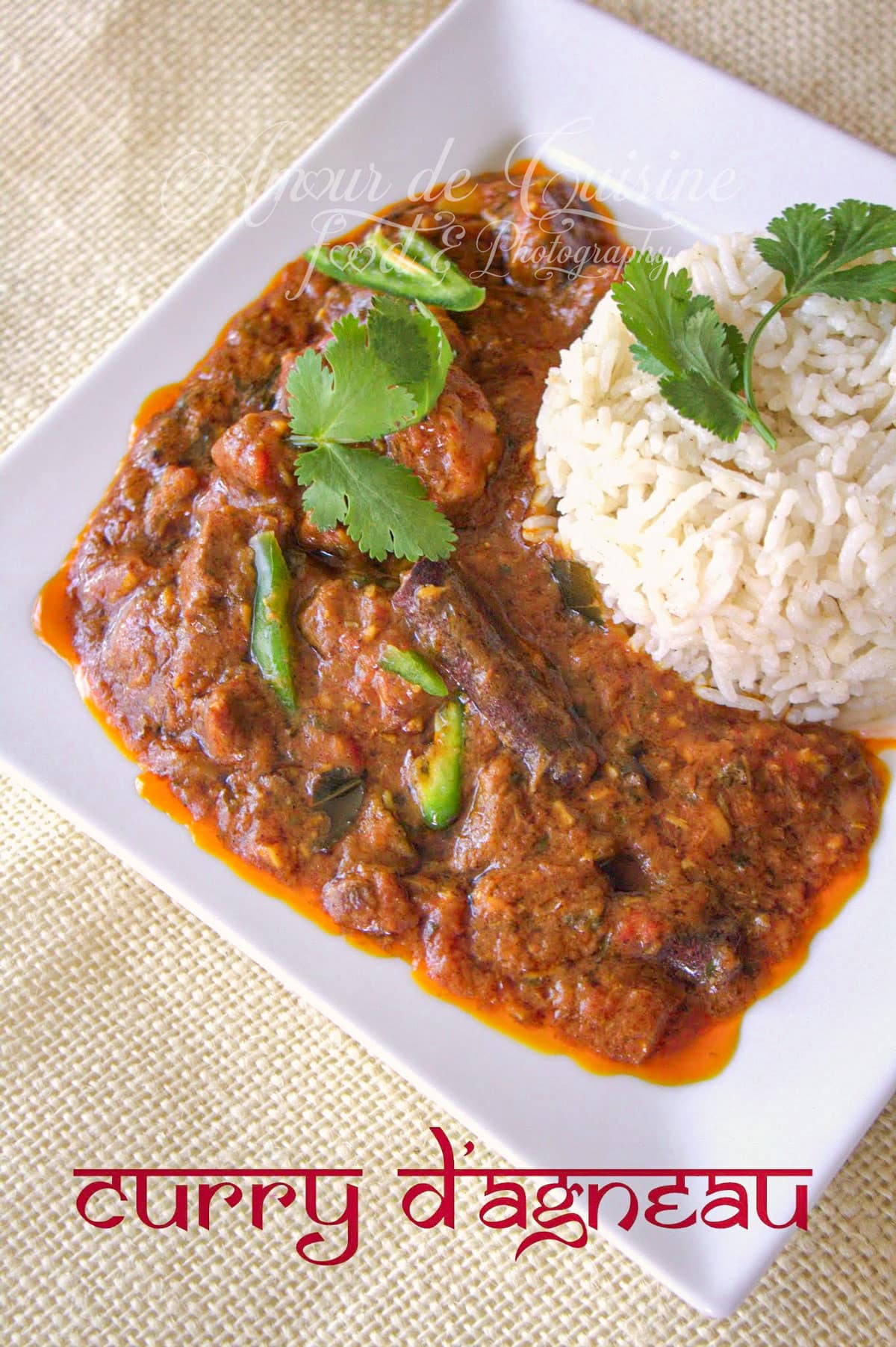 Top view of a square plate with homemade lamb curry topped with fresh coriander, served with basmati rice, on a beige tablecloth.