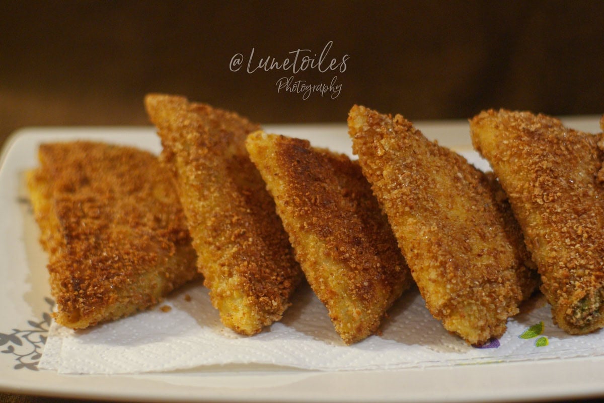 Samossas de crêpes panées dorés et croustillants, alignés sur un plat avec papier absorbant, prêts à servir pour l’apéritif.