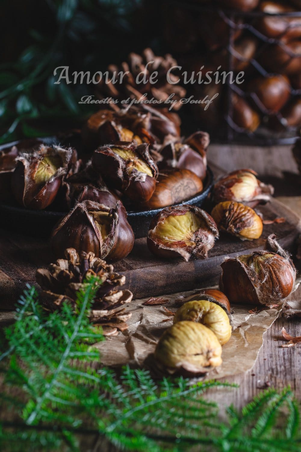 Oven-roasted chestnuts in their cracked shells, placed on a wooden board with pinecones and fir branches, in a rustic autumn atmosphere.
