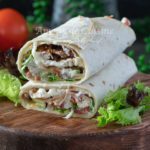 wrap au poulet coupé sur deux presenté avec une salade verte