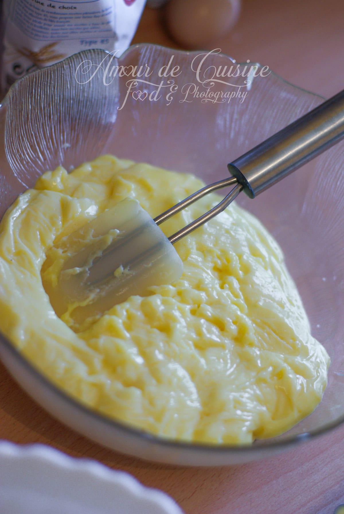 Crème pâtissière épaisse dans un grand saladier en verre, avec une spatule posée dedans, prête à être lissée avant de réaliser la frangipane.
