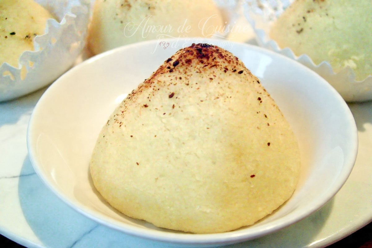 Montecao traditionnel saupoudré de cannelle, présenté en gros plan dans une petite coupelle blanche.