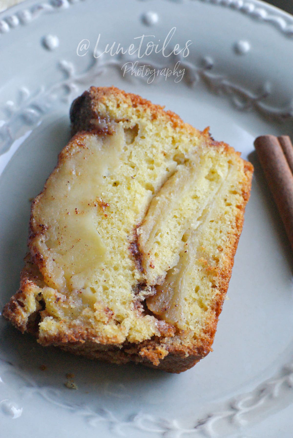 Tranche de cake aux pommes à l’ancienne moelleux, avec des lamelles de pommes fondantes et une note de cannelle.