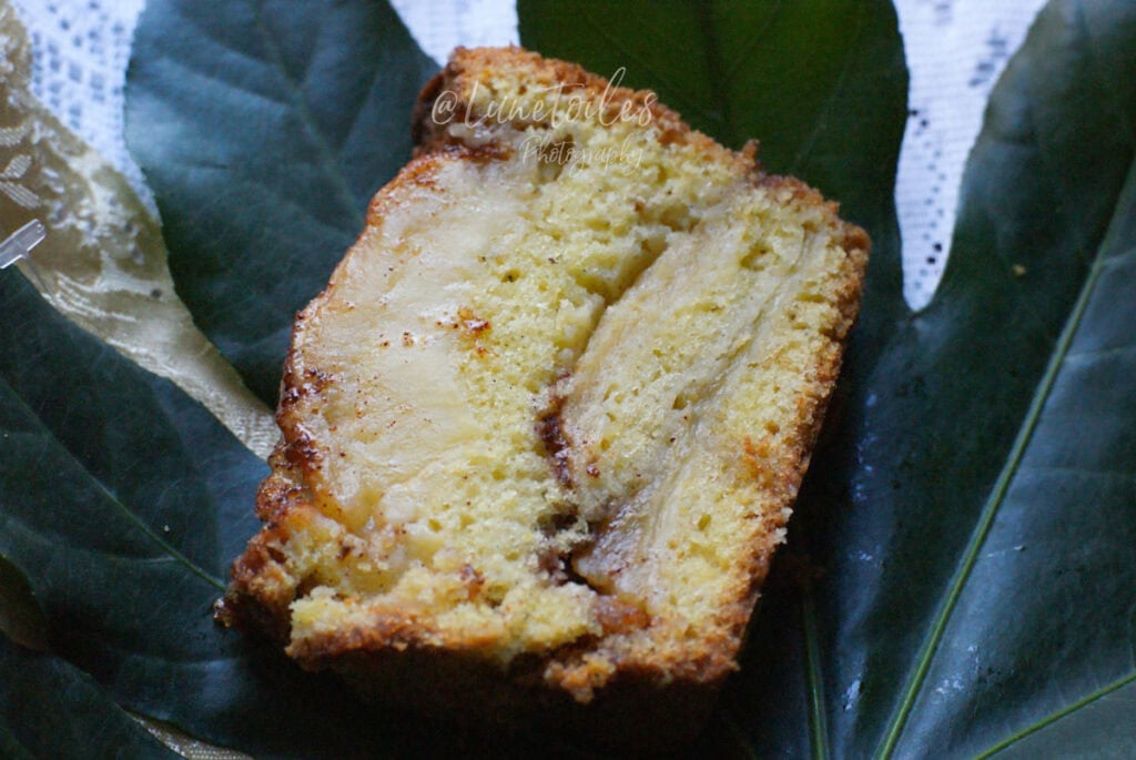 Tranche de cake aux pommes à l’ancienne moelleux, avec des lamelles de pommes fondantes et une touche de cannelle.