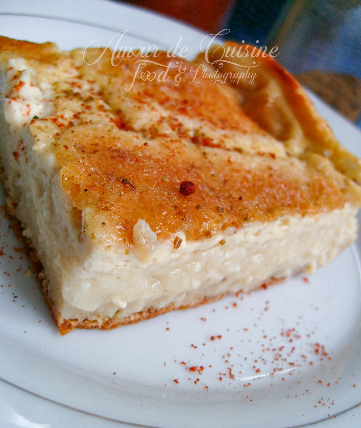 Part de garantita (karantika) algérienne sur une assiette blanche, montrant sa texture de flan de pois chiche, avec une surface dorée et une légère touche d’épices.
