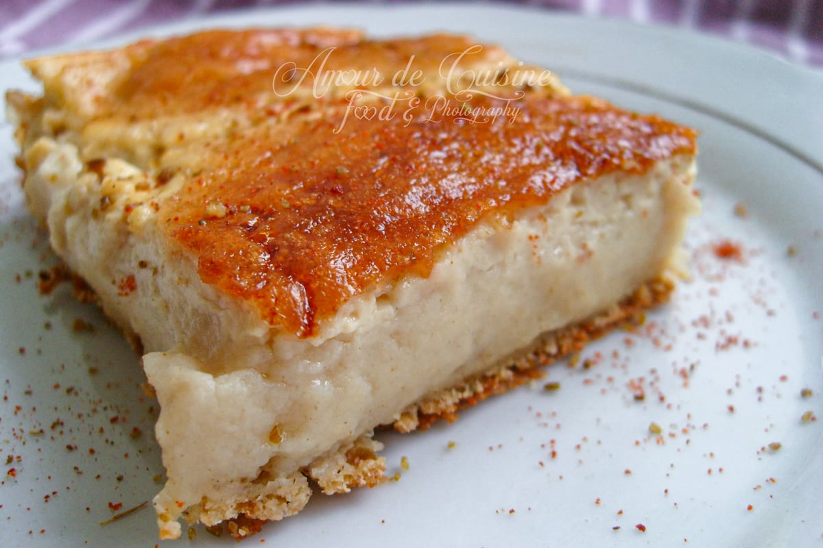 Part de garantita (karantika) algérienne dans une assiette, avec un intérieur crémeux au pois chiche et une croûte dorée brillante, légèrement saupoudrée d’épices.