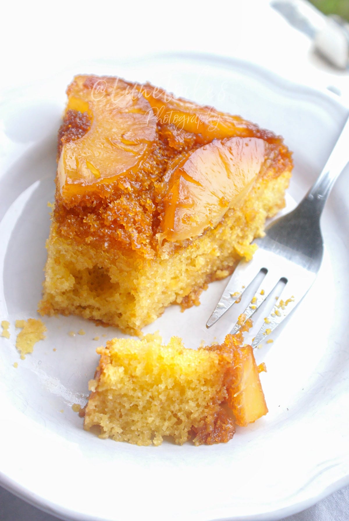 Part de gâteau renversé à l’ananas moelleux et caramélisé, tranches d’ananas dorées sur biscuit fondant, dessert facile fait maison servie à l’assiette.
