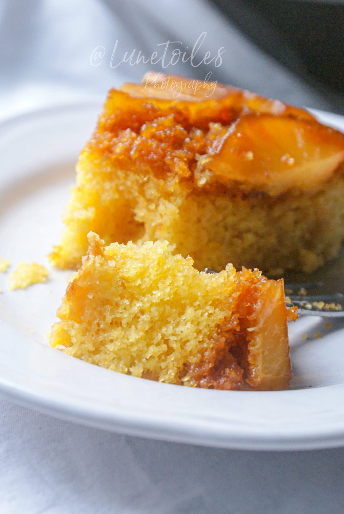 Gros plan sur une part de gâteau renversé à l’ananas moelleux et caramélisé, mie fondante et dorée, dessert maison facile servi à l’assiette.