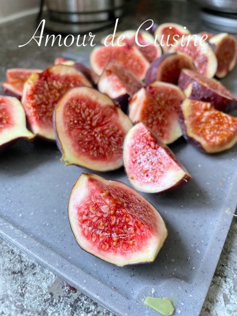 Quartiers de figues fraîches violettes coupées sur une planche, prêtes à être utilisées pour la préparation d’un confit maison au vinaigre balsamique