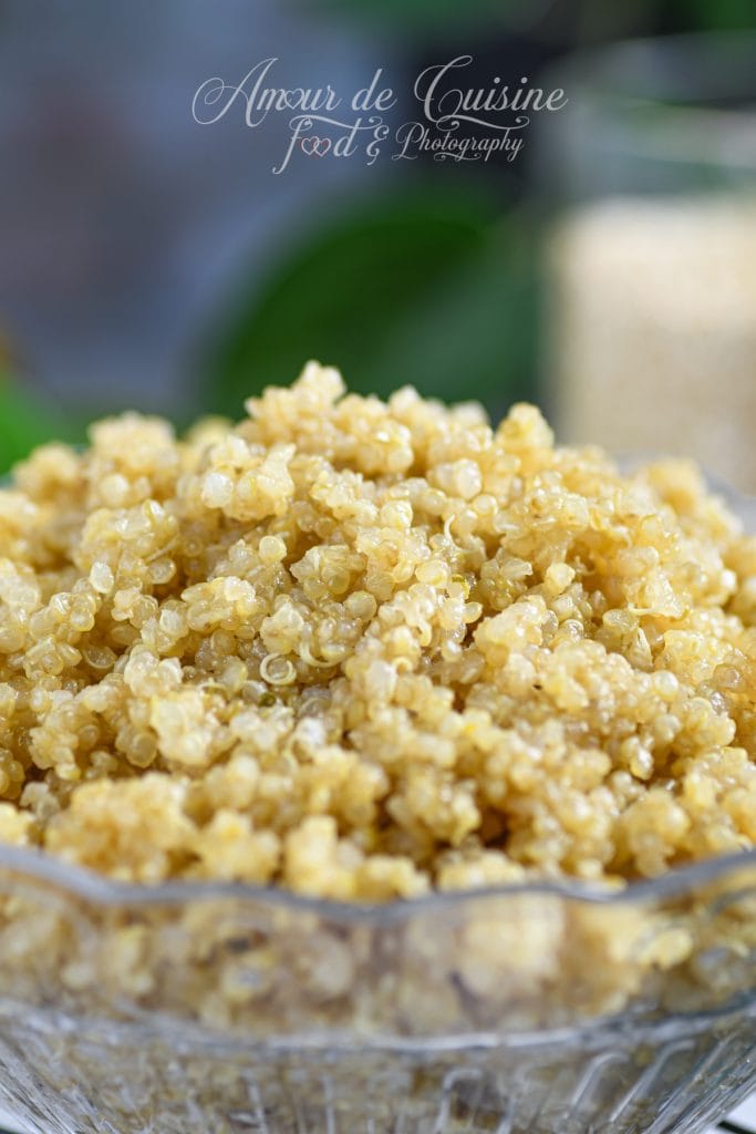 Gros plan sur un bol de quinoa parfaitement cuit, aux grains dorés et moelleux, mettant en valeur leur texture légère et brillante dans un saladier en verre transparent.
