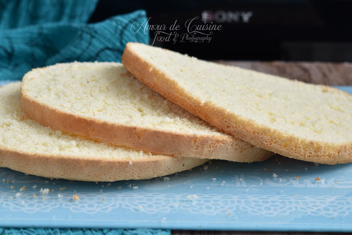 Sliced genoise sponge cake showing a soft, airy crumb and even layers, ready to be filled for a layered dessert or birthday cake.