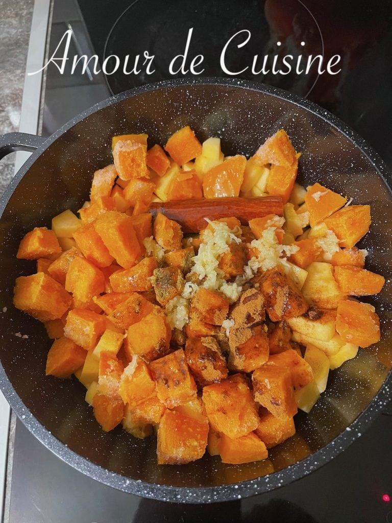 Morceaux de potiron dans une cocotte, assaisonnés de cannelle, cumin et ail râpé, prêts à mijoter lentement pour préparer la mrouzia constantinoise traditionnelle