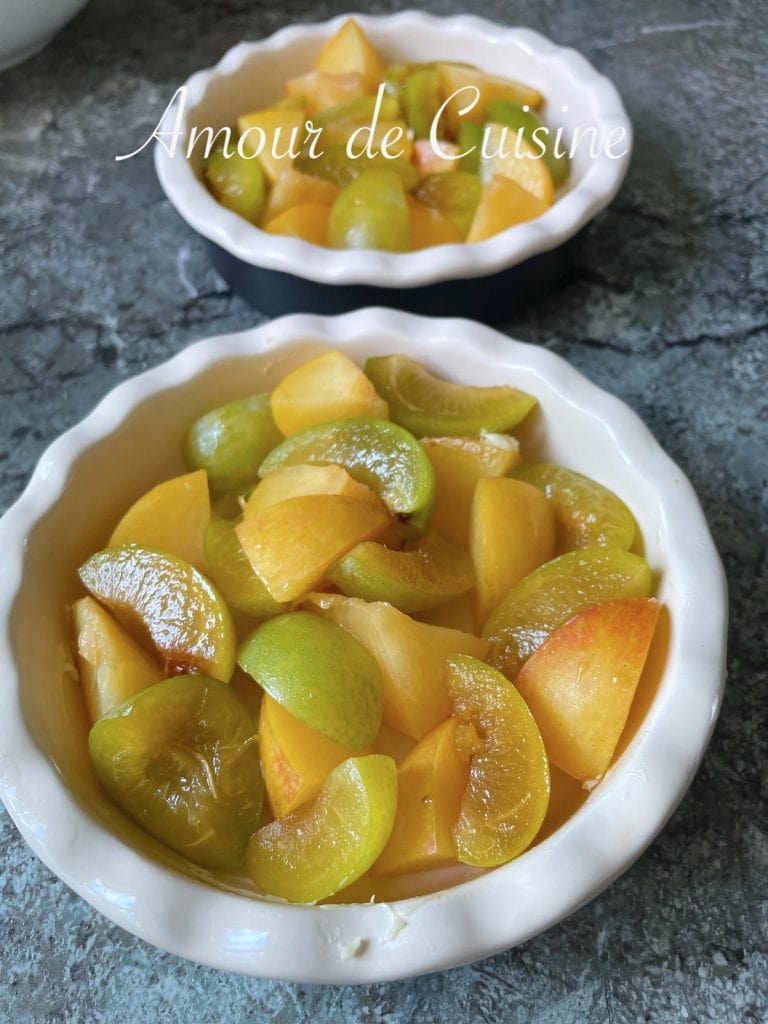 Moule à tartelette garni de quartiers de reines-claudes et de mirabelles fraîches, prêts à être transformés en crumble maison.