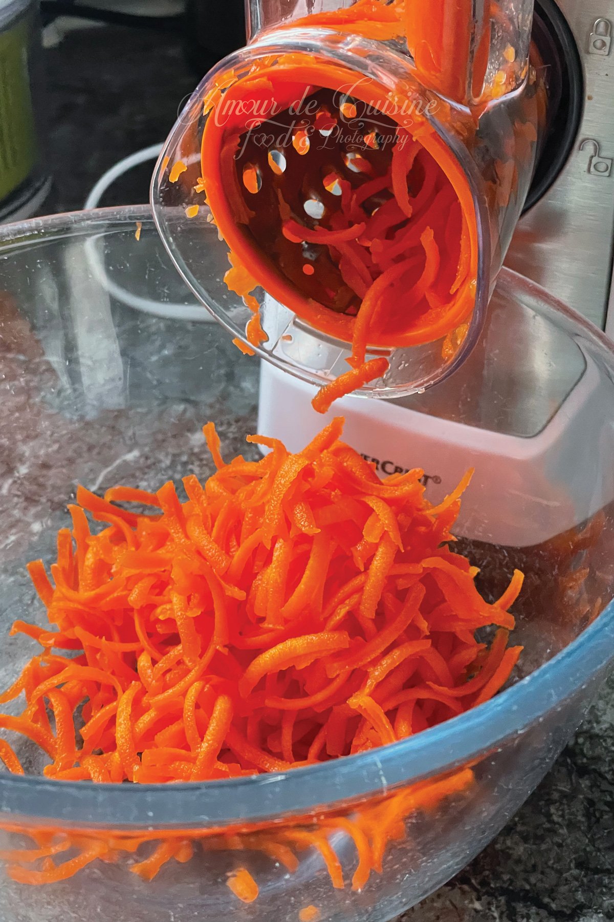 Carottes fraîchement râpées à la râpe rotative, tombant directement dans un saladier, pour une texture fine et croquante idéale en salade de crudités.