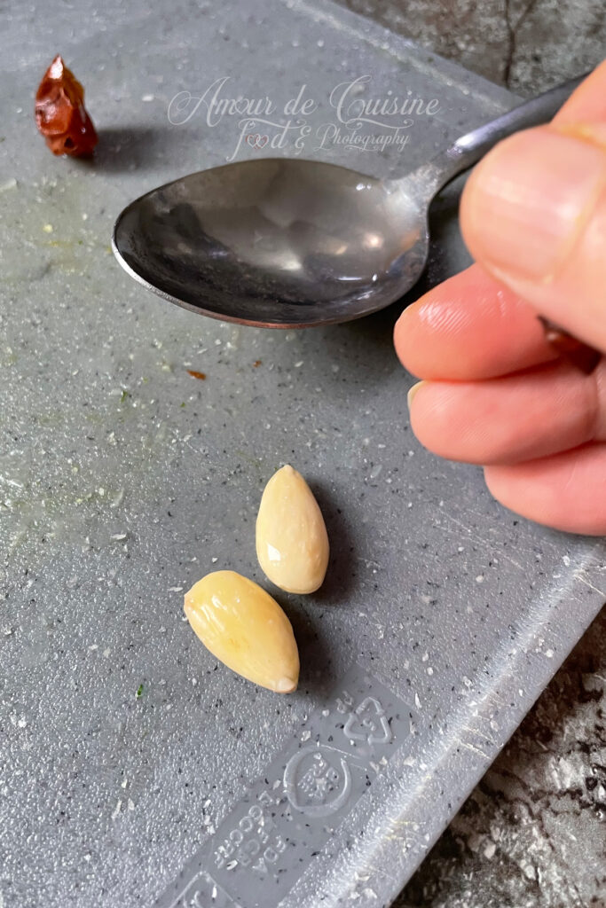 Geste pour émonder les amandes facilement après blanchiment, avec deux amandes sans peau prêtes à sécher avant d’être réduites en poudre.