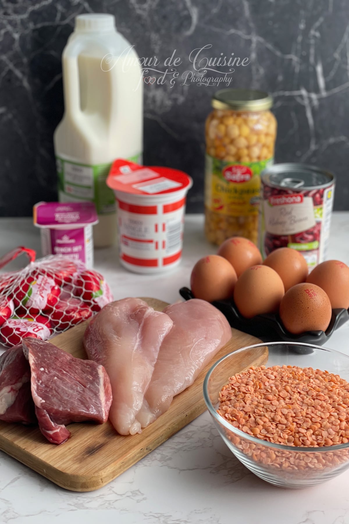 Ingrédients pour un menu régime protéiné : blancs de poulet, viande rouge, œufs, lentilles corail, lait, yaourts, pois chiches, haricots rouges et fromage.