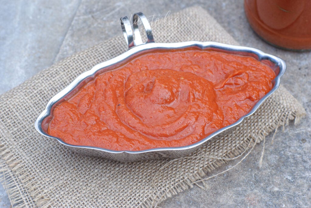 Sauce aux tomates rôties maison servie dans une saucière, à la texture lisse et épaisse, idéale pour accompagner pâtes, pizzas et gratins.