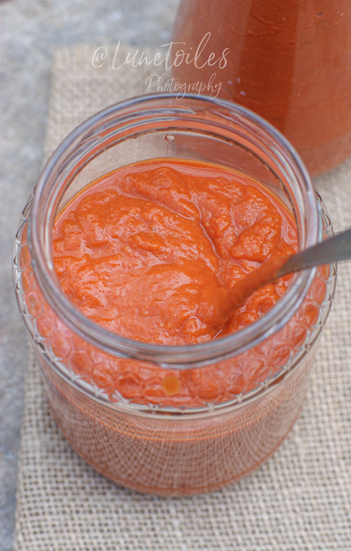 Sauce aux tomates rôties maison dans un pot en verre, à la texture épaisse et veloutée, prête à conserver ou à utiliser en cuisine.